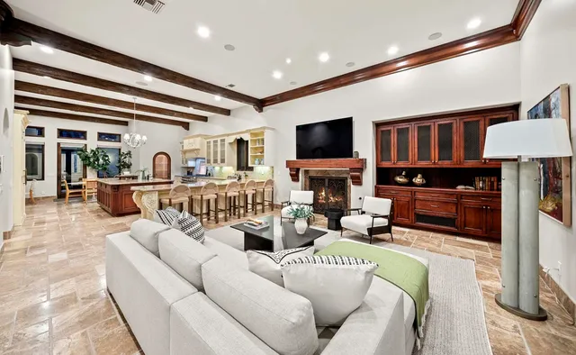 a living room with furniture kitchen view and large windows