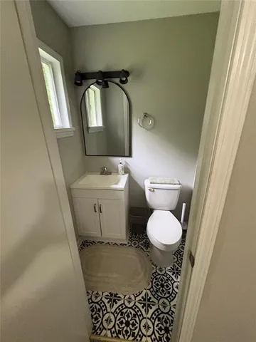 a bathroom with a toilet sink and mirror