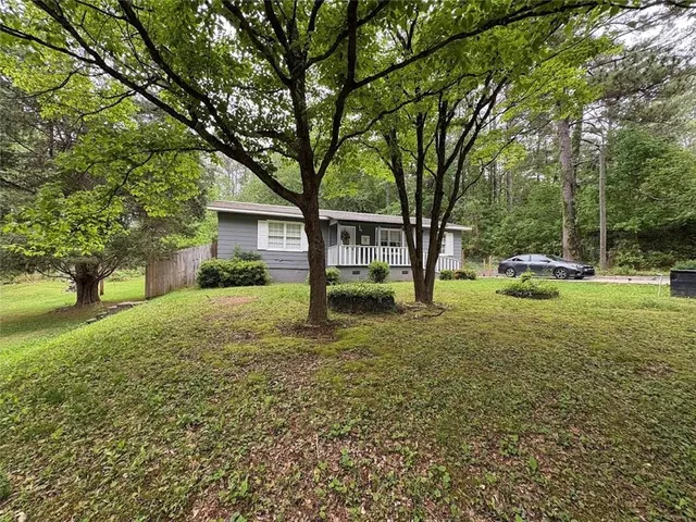 a front view of a house with a yard and trees