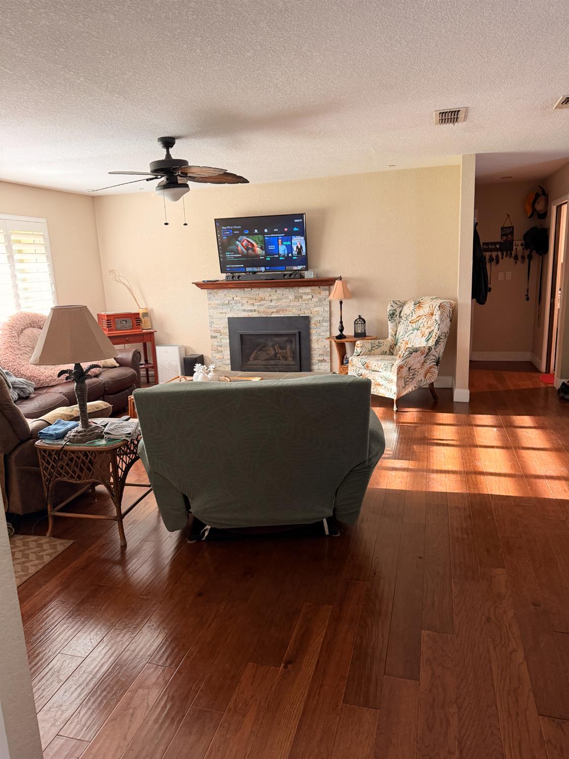 5645 20th Street Rio Linda, CA 95673 - Photo 29 of 69 living room featuring hardwood / wood-style floors, a fireplace, a ceiling fan, and a textured ceiling