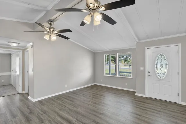 a view of an entryway with wooden floor and a ceiling fan