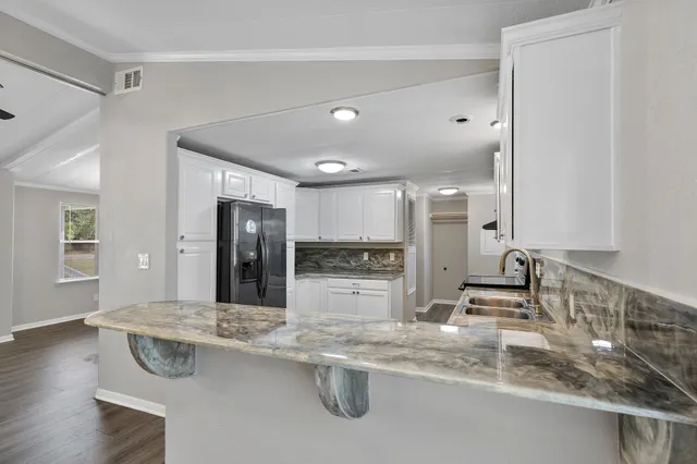 a kitchen with stainless steel appliances granite countertop a sink and a refrigerator