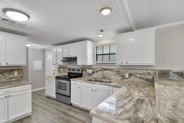 a kitchen with granite countertop a sink stainless steel appliances and cabinets