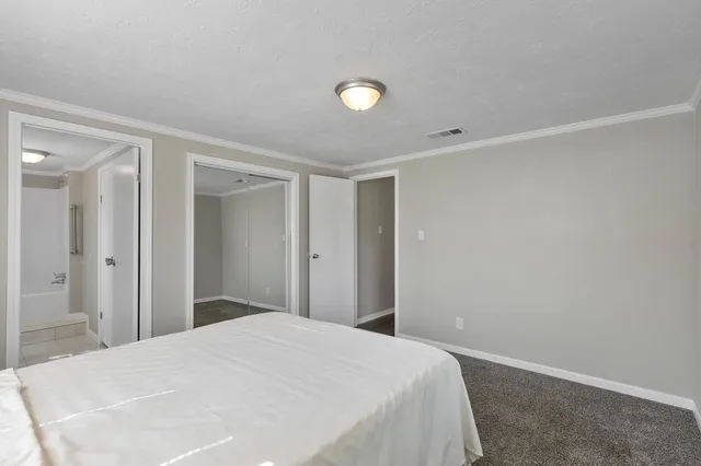 a bedroom with a bed and a bathroom