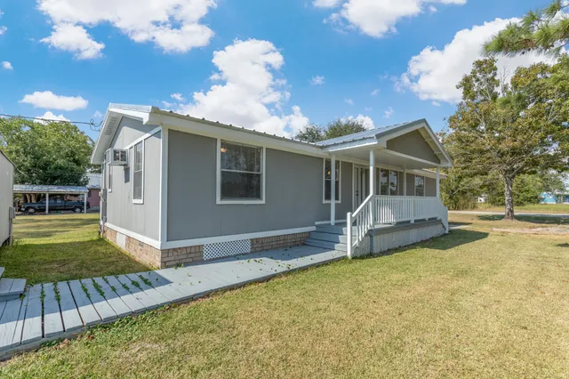 a view of a house with backyard and sitting area