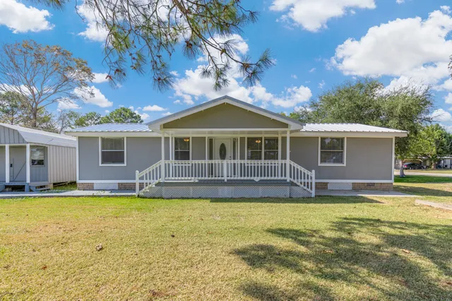 a view of a house with a swimming pool and a yard