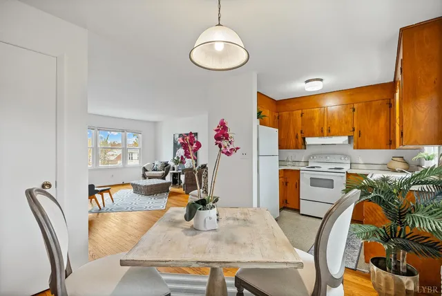 a view of a dining room with furniture a chandelier and wooden floor