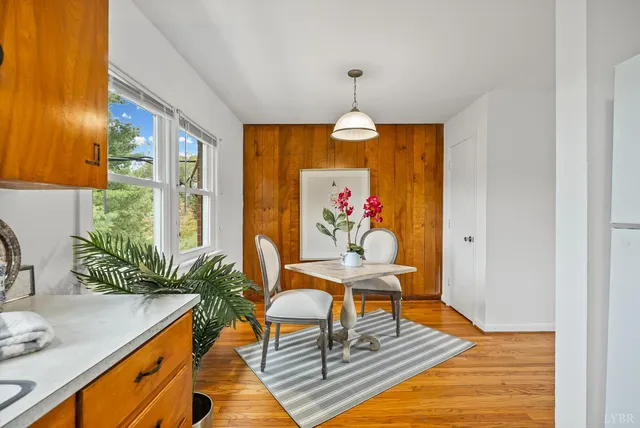 a view of a dining room with furniture a chandelier and wooden floor
