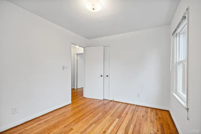 a view of empty room with wooden floor and entryway