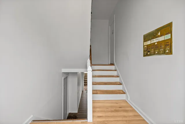 a view of a hallway with wooden floor and white walls