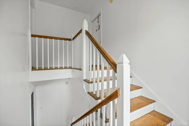 a view of staircase with railing and white walls