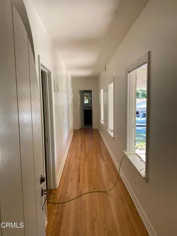 a view of a hallway with wooden floor and staircase