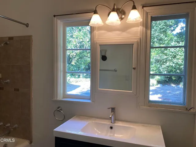 a bathroom with a sink a mirror and a window