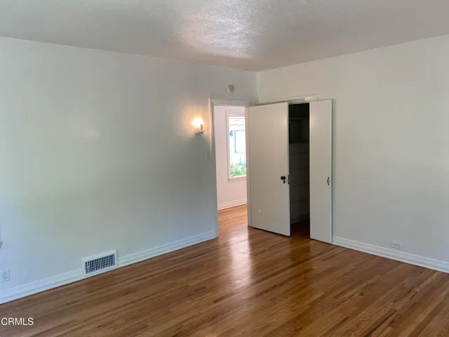 a view of an empty room with wooden floor