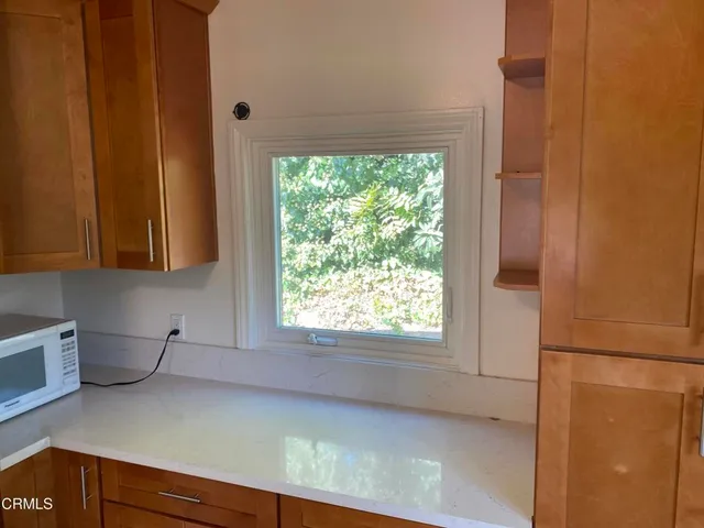 a kitchen with a window a refrigerator and cabinets