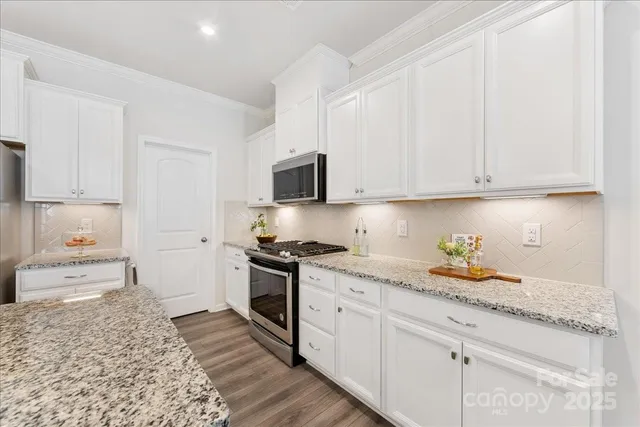 a kitchen with stainless steel appliances granite countertop a stove a sink and a refrigerator