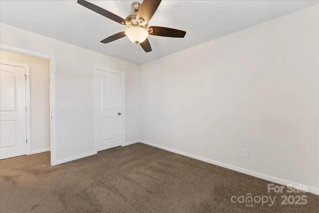an empty room with a window and a ceiling fan