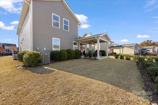 a view of a house with a patio and a yard