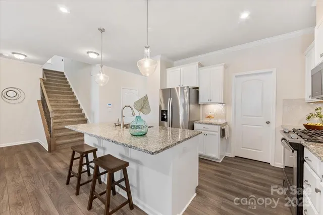 a kitchen with stainless steel appliances granite countertop counter space a sink refrigerator and cabinets