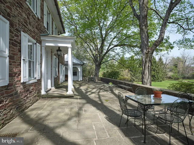 a view of a patio with table and chairs and floor to ceiling window
