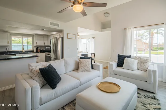 a kitchen with kitchen island granite countertop a refrigerator a sink a stove a microwave and wooden cabinets