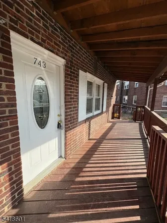a view of a porch with wooden floor and iron stairs
