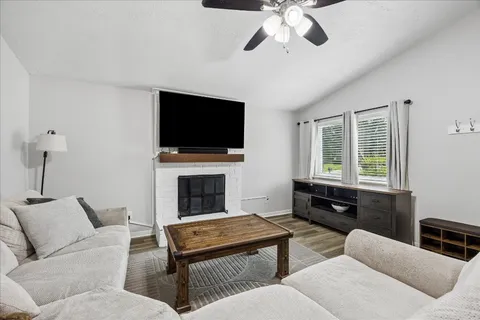 a living room with furniture a flat screen tv and a fireplace