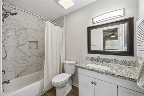a bathroom with a granite countertop sink toilet and shower