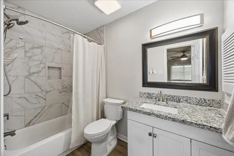 a bathroom with a granite countertop sink toilet and shower