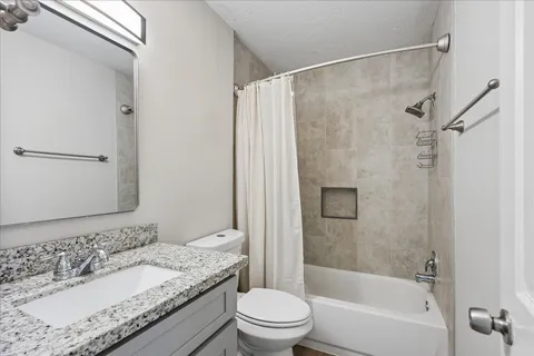 a bathroom with a granite countertop sink toilet and shower