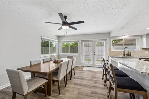 a dining room with furniture a chandelier and wooden floor