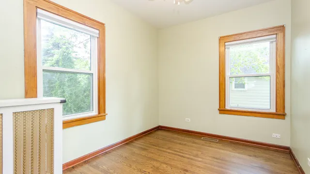 an empty room with wooden floor and closet area