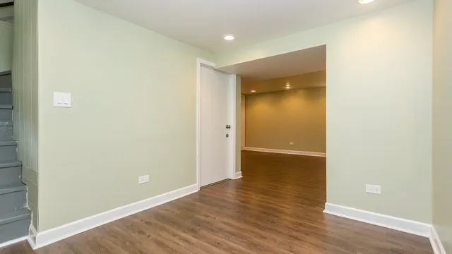 a view of empty room with wooden floor and entryway