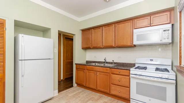 a kitchen with granite countertop white cabinets and stainless steel appliances