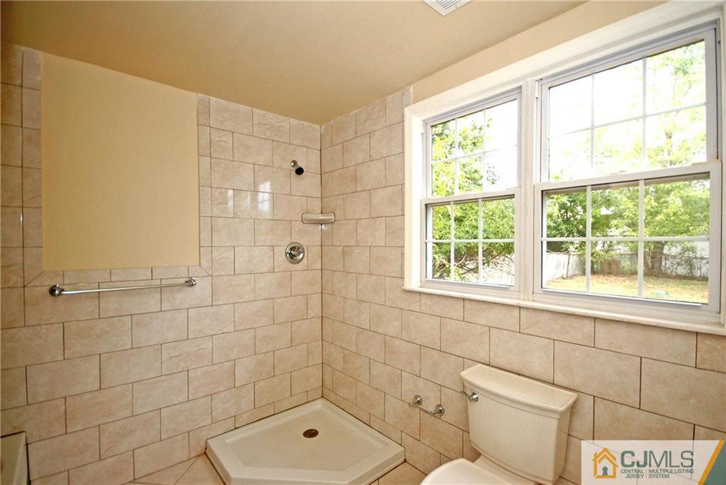 1227 Brookside Road Piscataway, NJ 08854 - Photo 19 of 22 a bathroom with a shower toilet and window