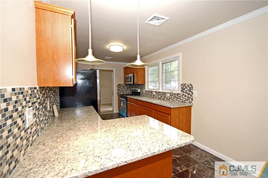 1227 Brookside Road Piscataway, NJ 08854 - Photo 3 of 22 a kitchen with stainless steel appliances granite countertop a sink stove and refrigerator