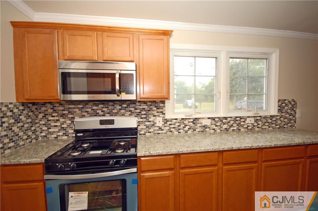 1227 Brookside Road Piscataway, NJ 08854 - Photo 6 of 22 a kitchen with granite countertop cabinets stove top oven and microwave