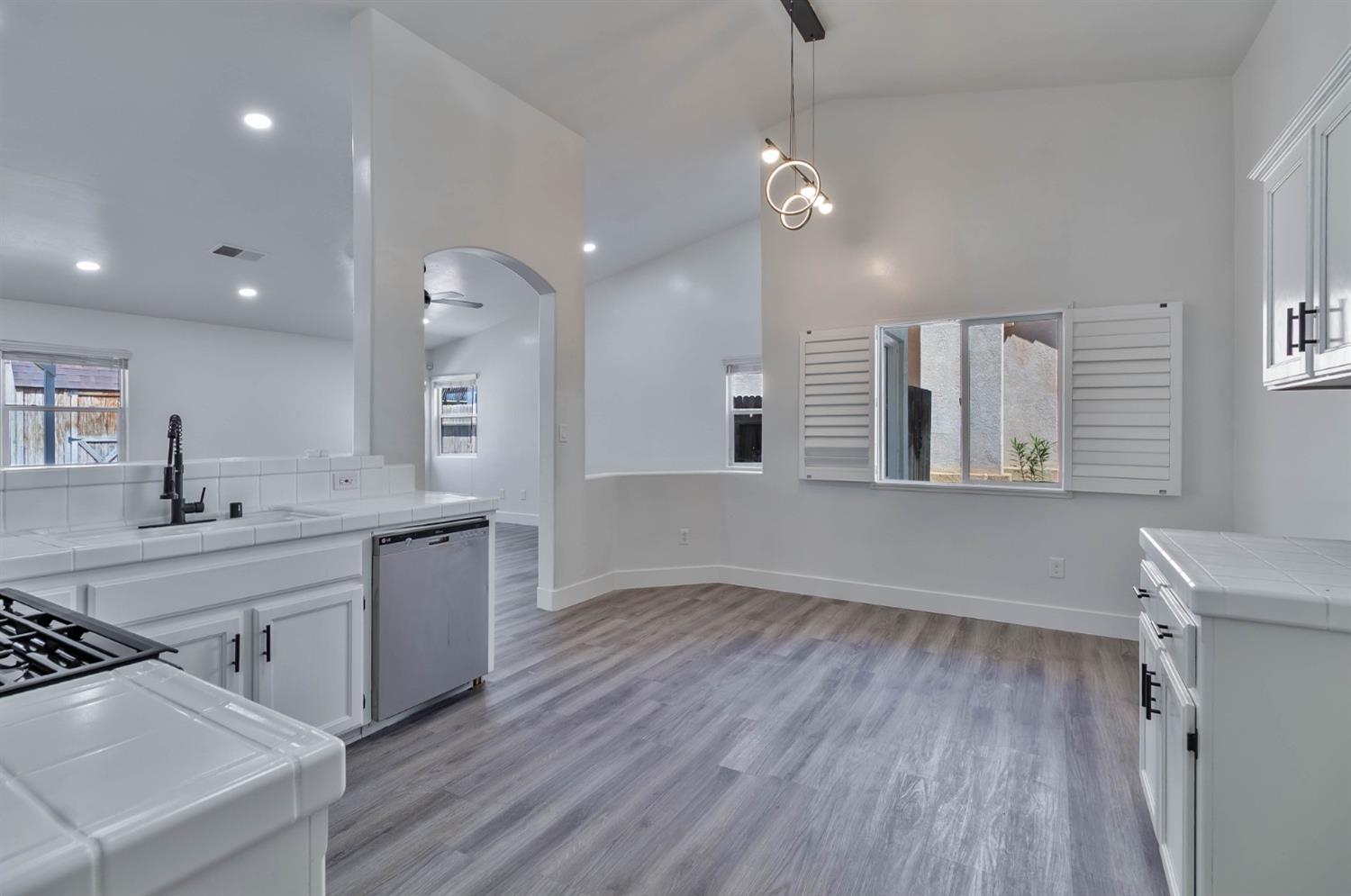 7110 Firebaugh Street Bakersfield, CA 93313 - Photo 11 of 37 a large kitchen with stainless steel appliances a large window a sink and a oven