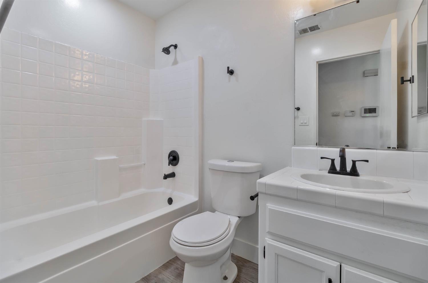 7110 Firebaugh Street Bakersfield, CA 93313 - Photo 19 of 37 a bathroom with a sink toilet vanity and shower