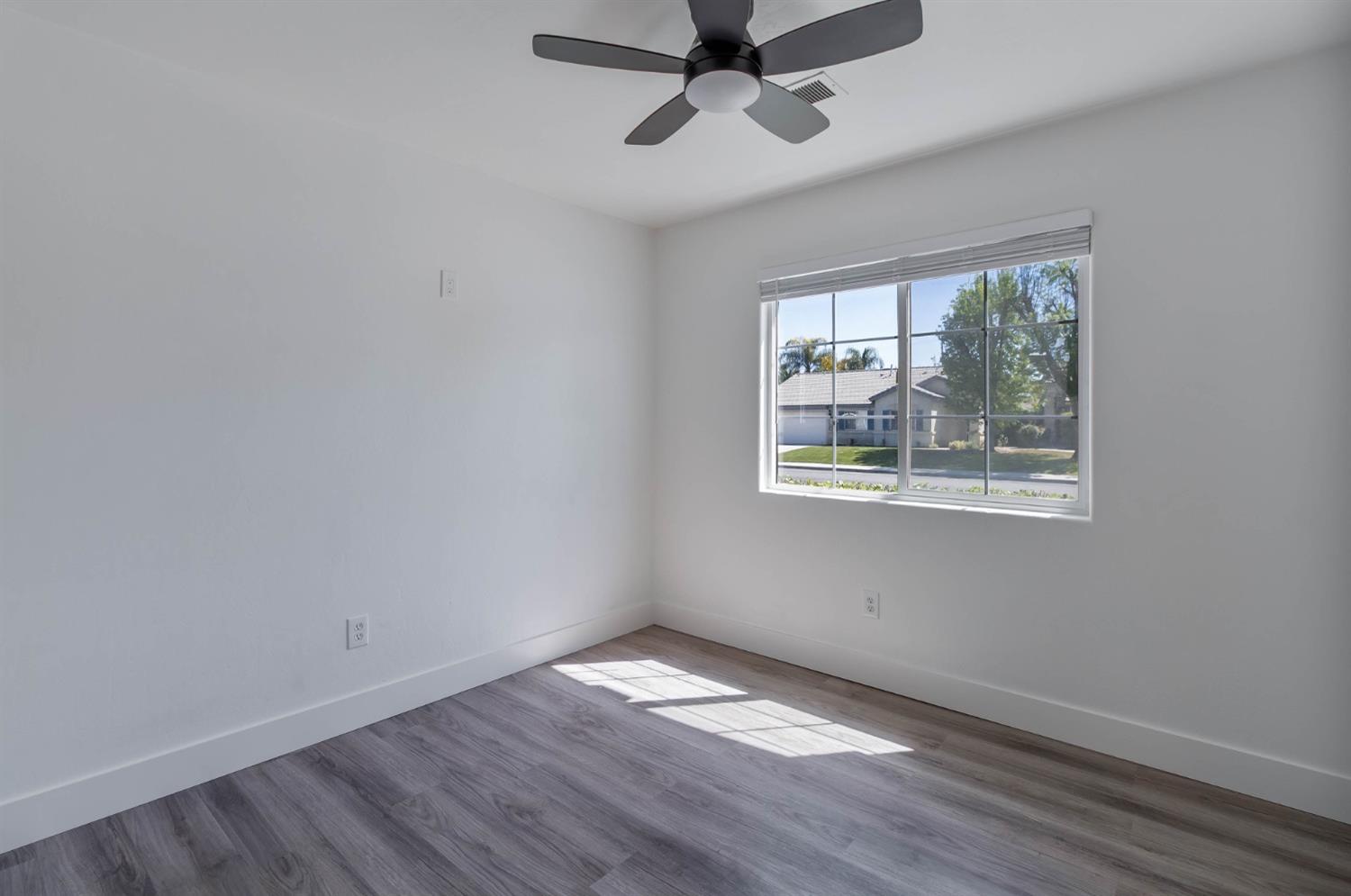 7110 Firebaugh Street Bakersfield, CA 93313 - Photo 20 of 37 wooden floor in an empty room with a window