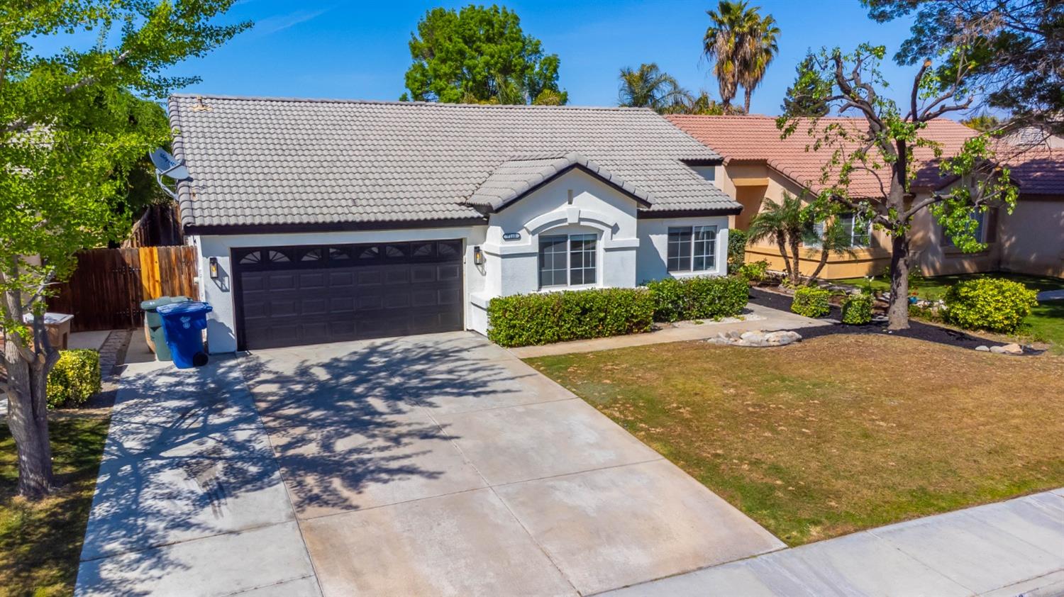 7110 Firebaugh Street Bakersfield, CA 93313 - Photo 25 of 37 a front view of a house with a yard and garage
