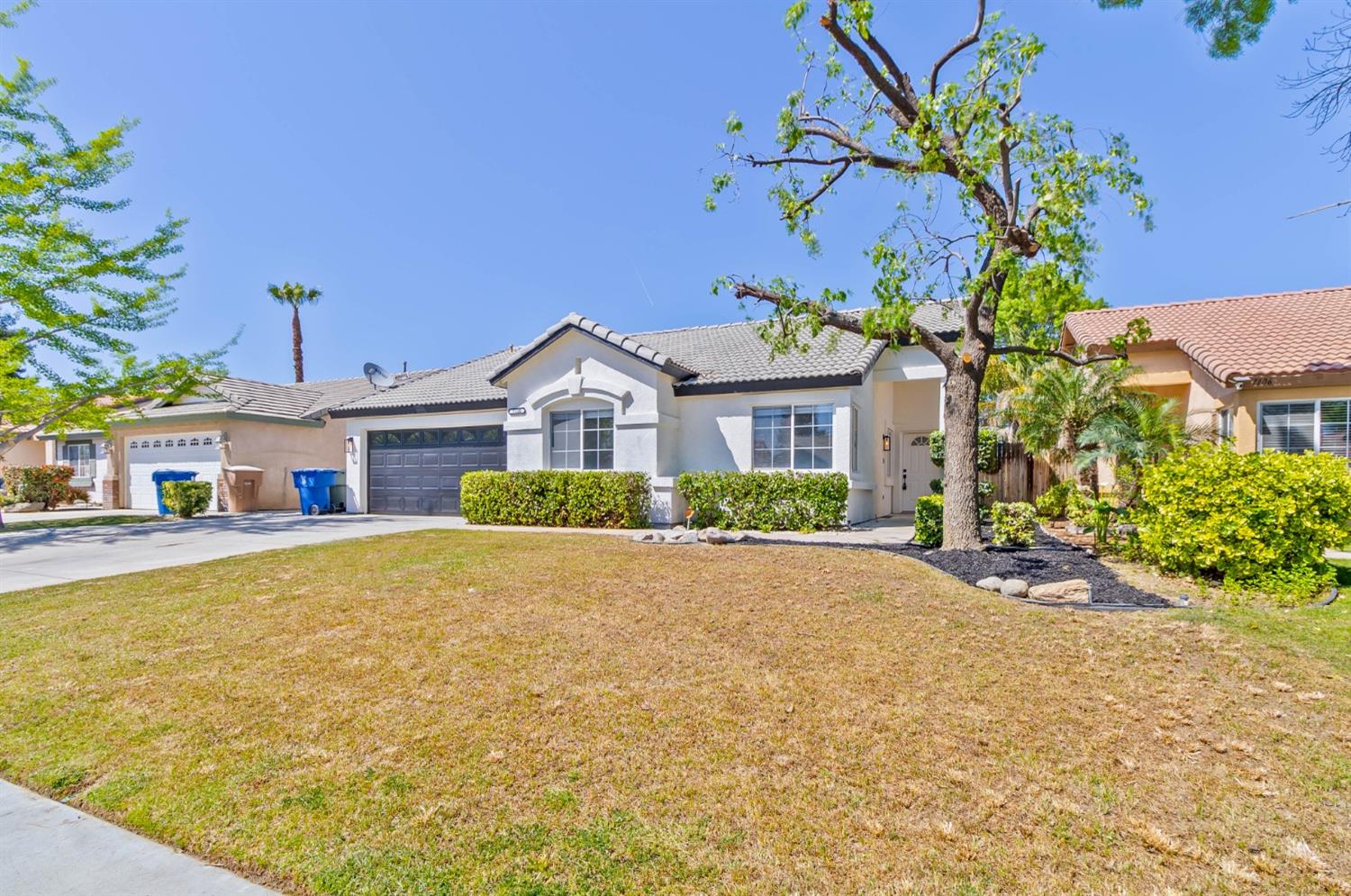 7110 Firebaugh Street Bakersfield, CA 93313 - Photo 29 of 37 a front view of a house with a yard and garage