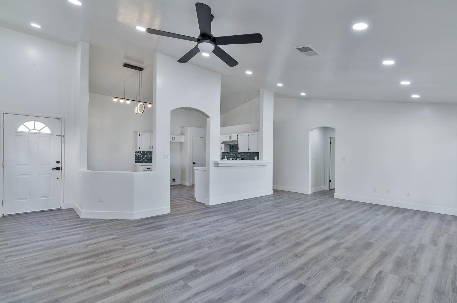 7110 Firebaugh Street Bakersfield, CA 93313 - Photo 3 of 37 a view of a kitchen with wooden floor and a ceiling fan