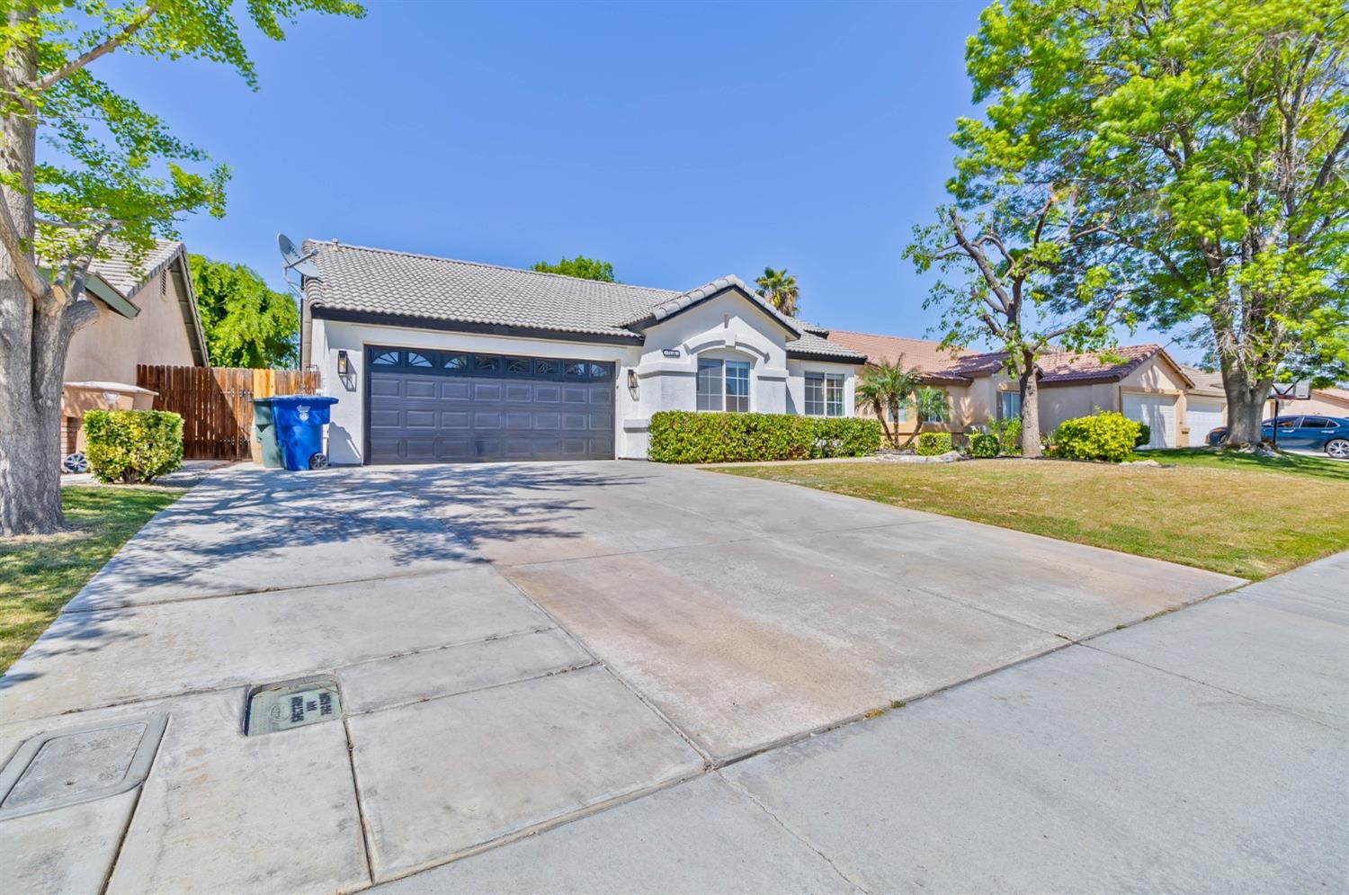 7110 Firebaugh Street Bakersfield, CA 93313 - Photo 31 of 37 a front view of a house with a yard and garage