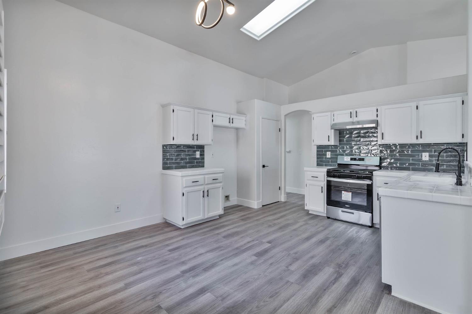 7110 Firebaugh Street Bakersfield, CA 93313 - Photo 6 of 37 a kitchen with stainless steel appliances a refrigerator and a stove top oven