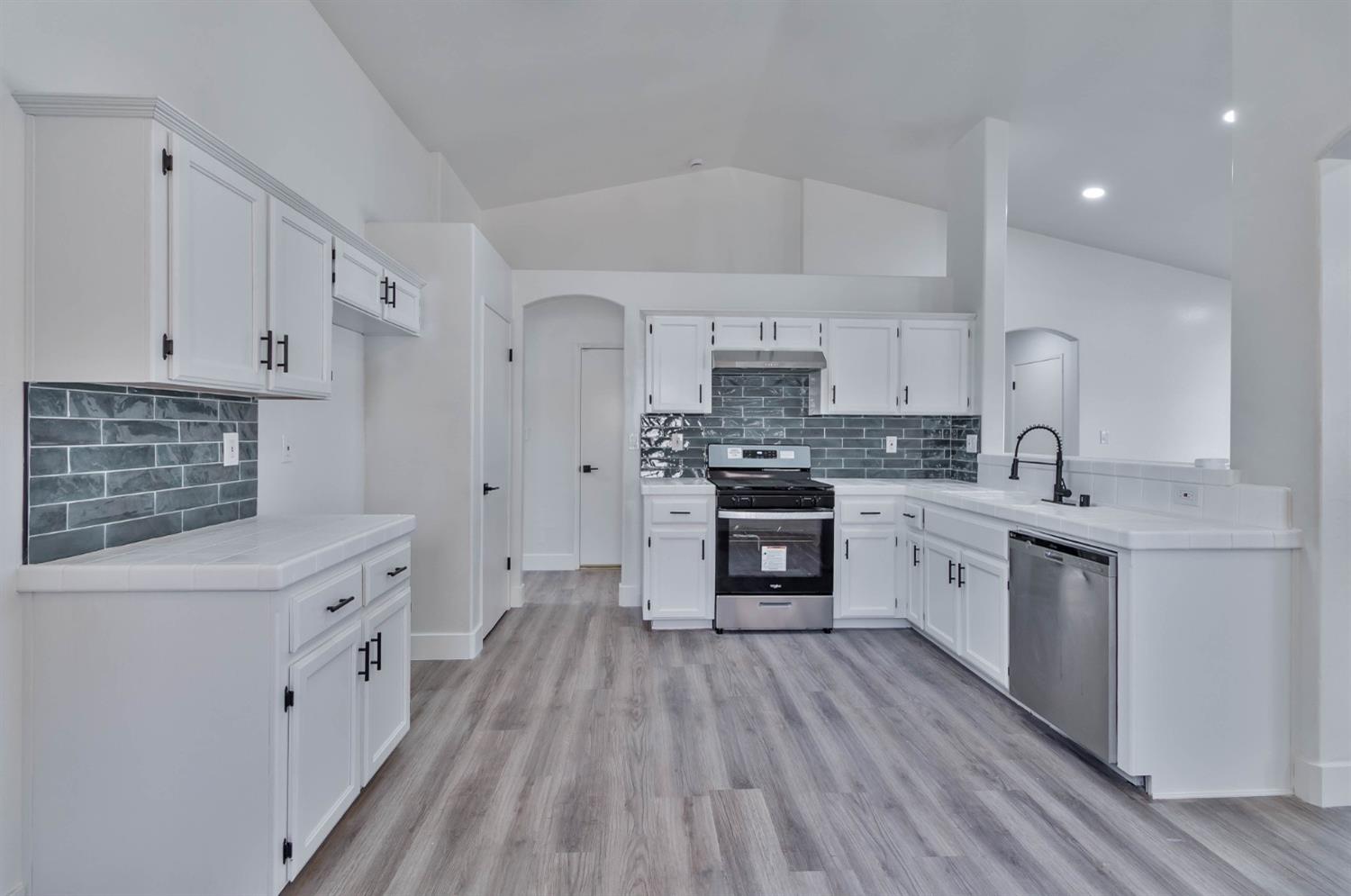 7110 Firebaugh Street Bakersfield, CA 93313 - Photo 8 of 37 a kitchen with stainless steel appliances a white cabinets and sink