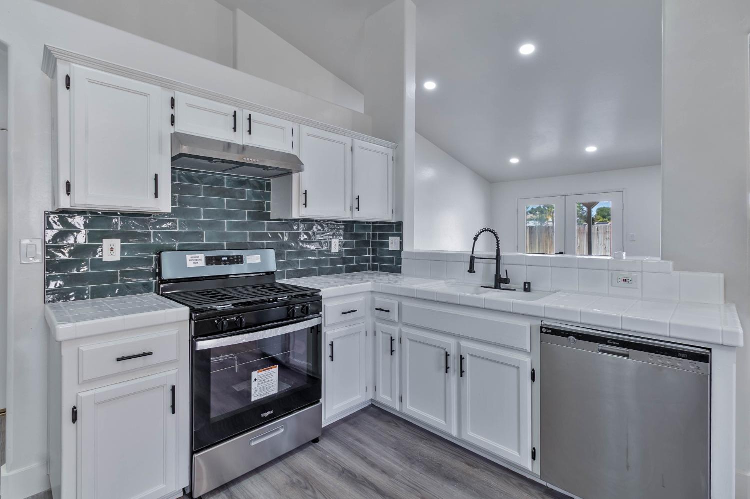 7110 Firebaugh Street Bakersfield, CA 93313 - Photo 10 of 37 a kitchen with a stove sink and cabinets