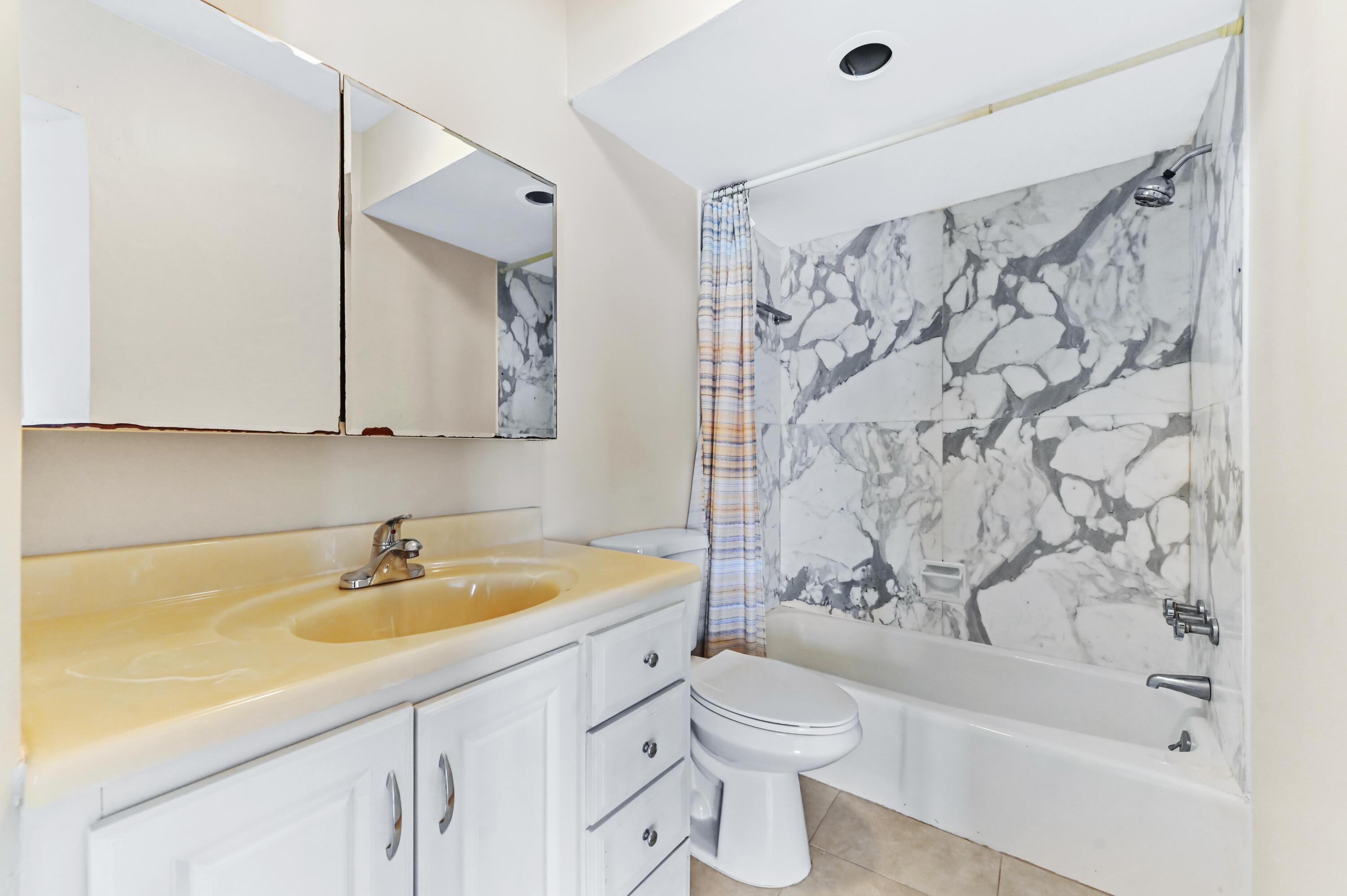 710 North Ocean Boulevard, Unit 710 Pompano Beach, FL 33062 - Photo 27 of 42 a bathroom with a sink a toilet and a bathtub