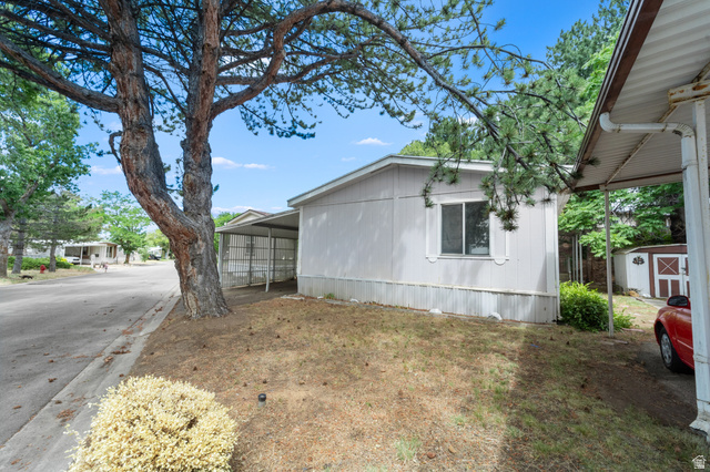 2875 North 400 West, Unit 7 Layton, UT 84041 - Photo 21 of 29 Single-story home featuring light-toned siding, a white-trimmed window, and a covered carport