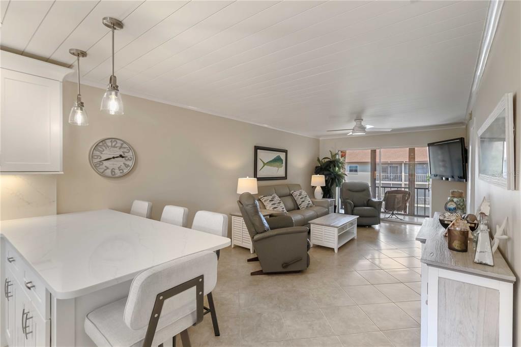 2240 Stickney Point Road, Unit 238 Sarasota, FL 34231 - Photo 3 of 17 a living room with furniture a clock and a chandelier